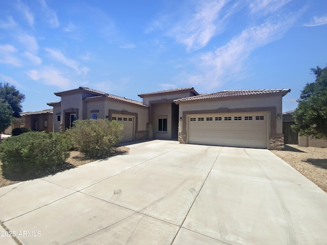 2971 N Rosewood Ave, Casa Grande, AZ 85122 - mediterranean / spanish home with stone siding, a garage, concrete driveway, and stucco siding