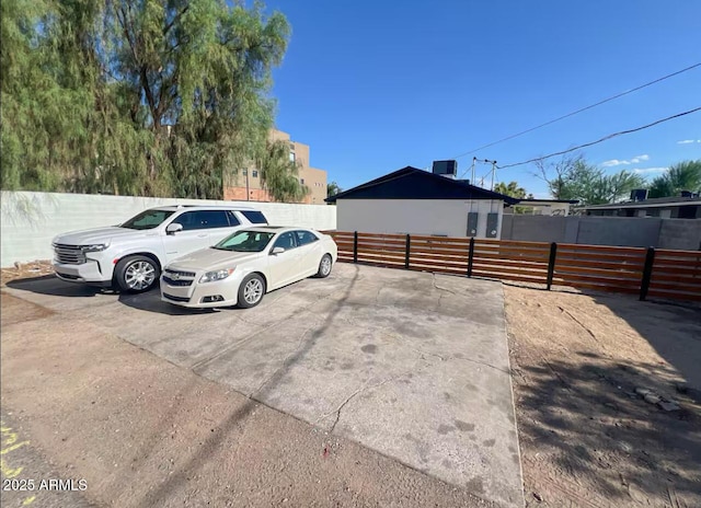 uncovered parking lot featuring fence