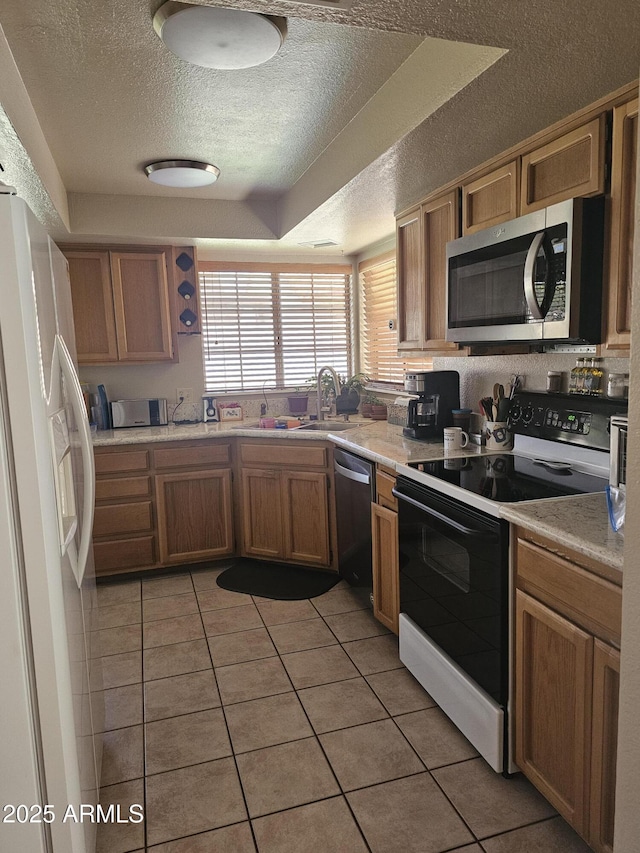 6036 W Mescal St, Glendale, AZ 85304 - kitchen featuring appliances with stainless steel finishes, a textured ceiling, light tile patterned flooring, light countertops, and a sink