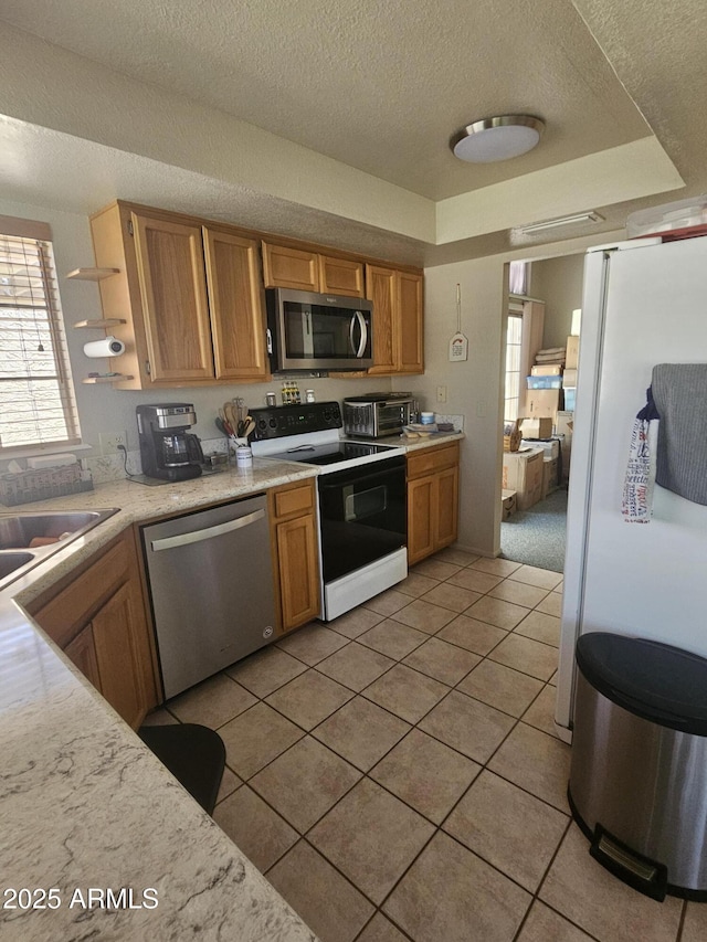6036 W Mescal St, Glendale, AZ 85304 - kitchen with stainless steel appliances, light countertops, a textured ceiling, a sink, and light tile patterned floors