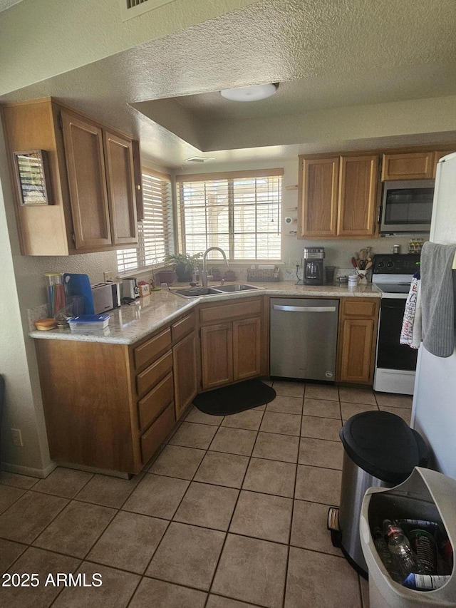 6036 W Mescal St, Glendale, AZ 85304 - kitchen featuring stainless steel appliances, a sink, light tile patterned floors, light countertops, and a textured ceiling
