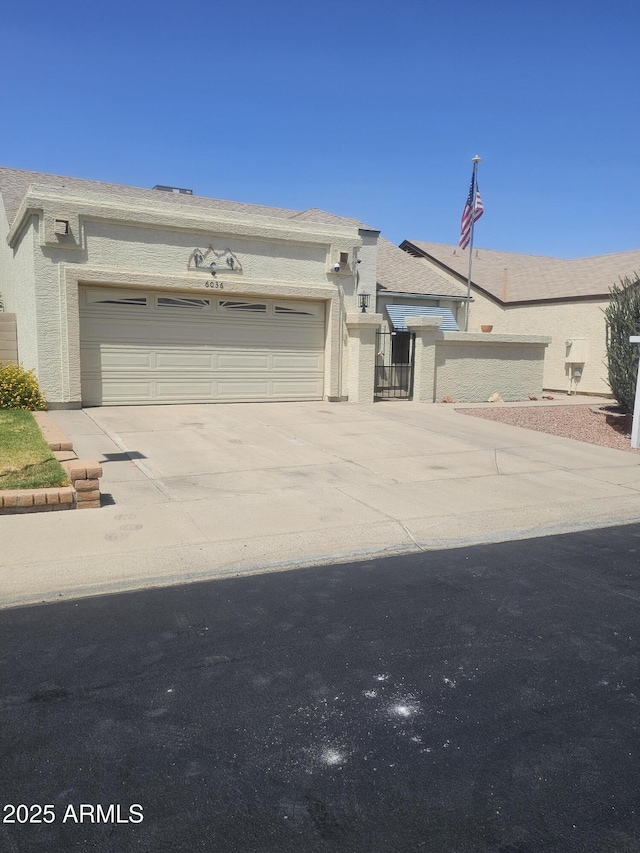 6036 W Mescal St, Glendale, AZ 85304 - view of front of property with concrete driveway, an attached garage, and stucco siding
