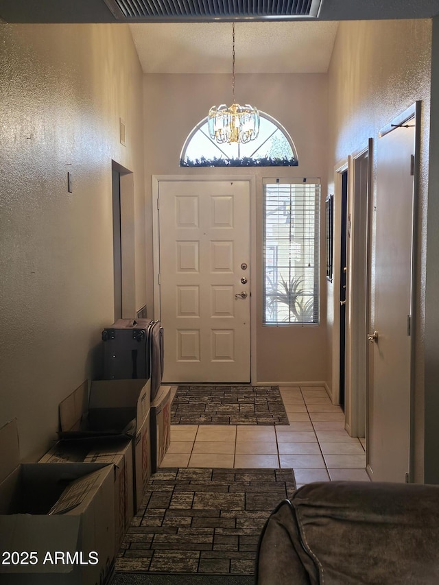 6036 W Mescal St, Glendale, AZ 85304 - foyer entrance with plenty of natural light, a chandelier, light tile patterned flooring, and a high ceiling