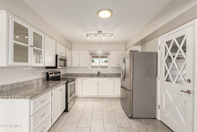 6022 E Colby St, Mesa, AZ 85205 - kitchen featuring appliances with stainless steel finishes, white cabinets, light stone counters, tasteful backsplash, and glass insert cabinets