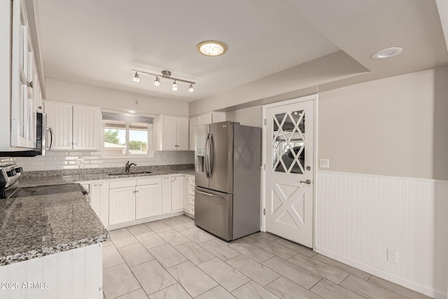 6022 E Colby St, Mesa, AZ 85205 - kitchen with appliances with stainless steel finishes, light stone countertops, white cabinets, a wainscoted wall, and decorative backsplash