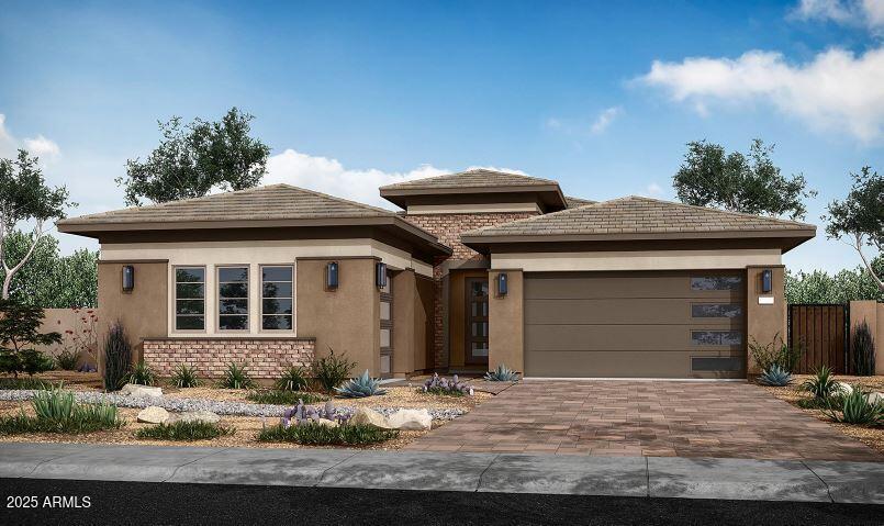 prairie-style home with a garage, decorative driveway, fence, and stucco siding