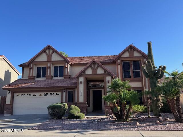 6928 W Oraibi Dr, Glendale, AZ 85308 - tudor-style house with an attached garage, driveway, and stucco siding