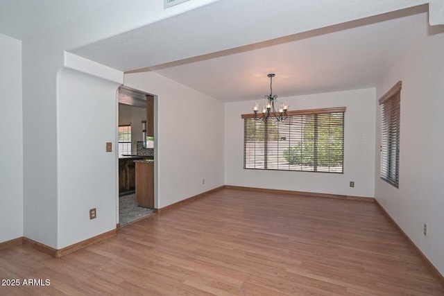 6928 W Oraibi Dr, Glendale, AZ 85308 - unfurnished room with light wood-type flooring, a chandelier, and baseboards