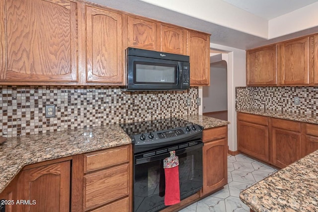 6928 W Oraibi Dr, Glendale, AZ 85308 - kitchen with black appliances, backsplash, brown cabinets, and light stone counters