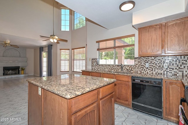 6928 W Oraibi Dr, Glendale, AZ 85308 - kitchen featuring dishwasher, ceiling fan, a sink, backsplash, and a kitchen island