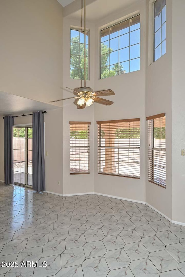 6928 W Oraibi Dr, Glendale, AZ 85308 - unfurnished room featuring a towering ceiling, ceiling fan, and baseboards