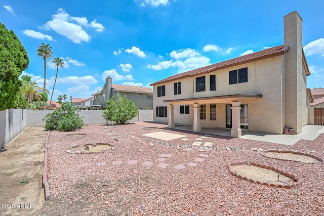 6928 W Oraibi Dr, Glendale, AZ 85308 - rear view of house featuring stucco siding, a fenced backyard, a patio area, and a chimney
