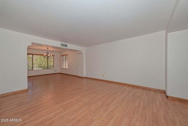 6928 W Oraibi Dr, Glendale, AZ 85308 - spare room with a chandelier, light wood finished floors, and baseboards