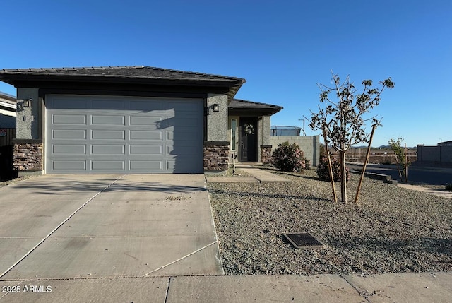view of front of property featuring concrete driveway, a garage, stone siding, and stucco siding
