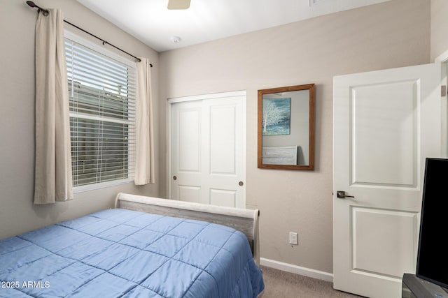 bedroom featuring baseboards, light carpet, a closet, and a ceiling fan