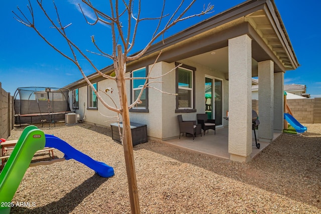 view of patio / terrace featuring a trampoline, cooling unit, and a fenced backyard