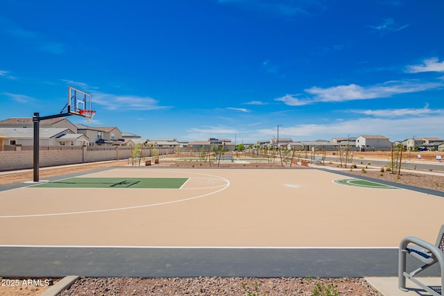 view of basketball court featuring a residential view, community basketball court, and fence