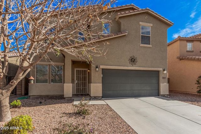 view of front facade featuring concrete driveway, a tiled roof, an attached garage, and stucco siding