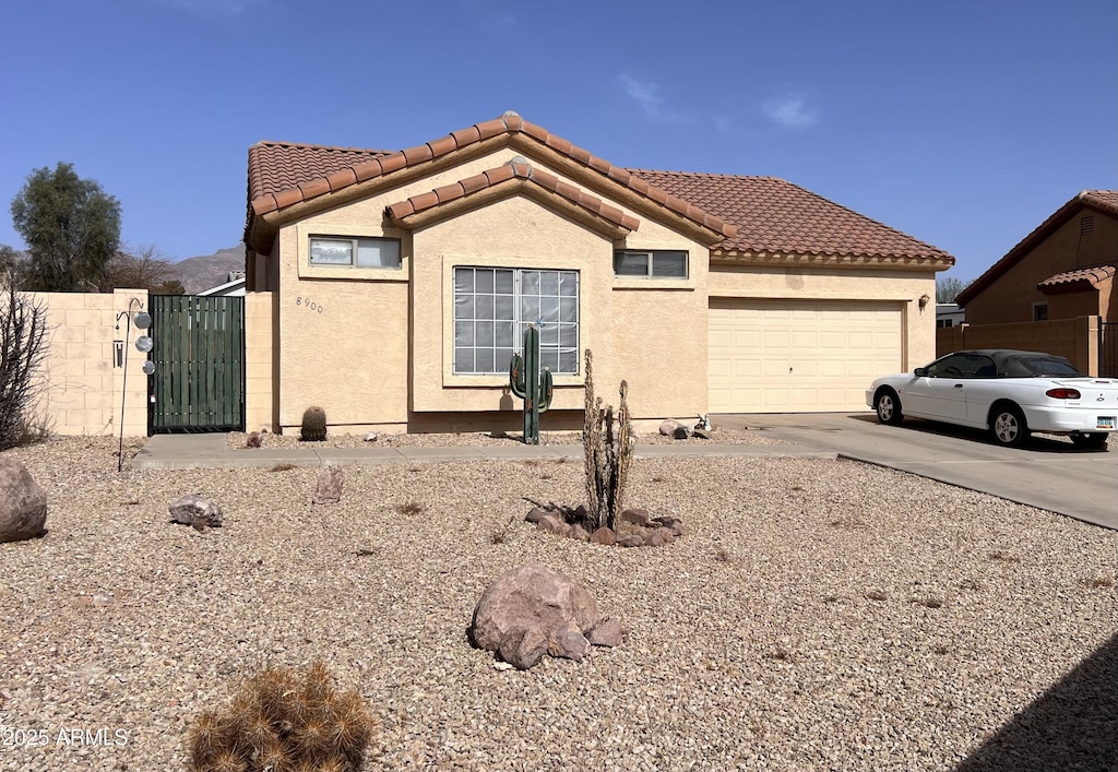 view of front of property with stucco siding, concrete driveway, an attached garage, and a tile roof