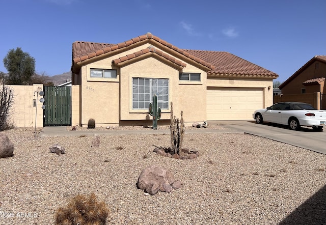 view of front of property with stucco siding, concrete driveway, an attached garage, and a tile roof