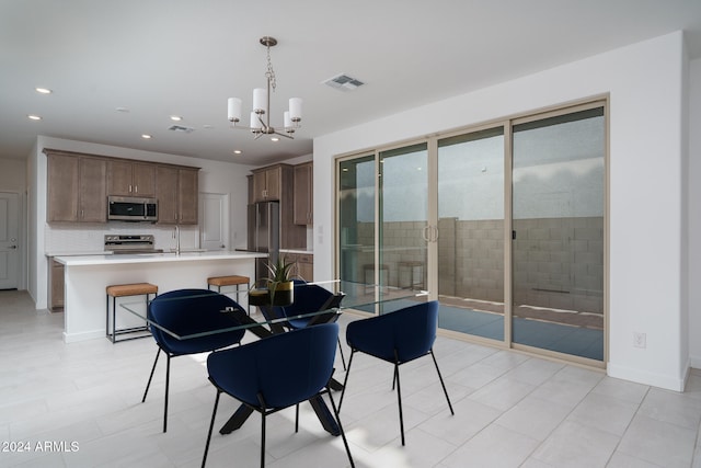 tiled dining area with sink and an inviting chandelier