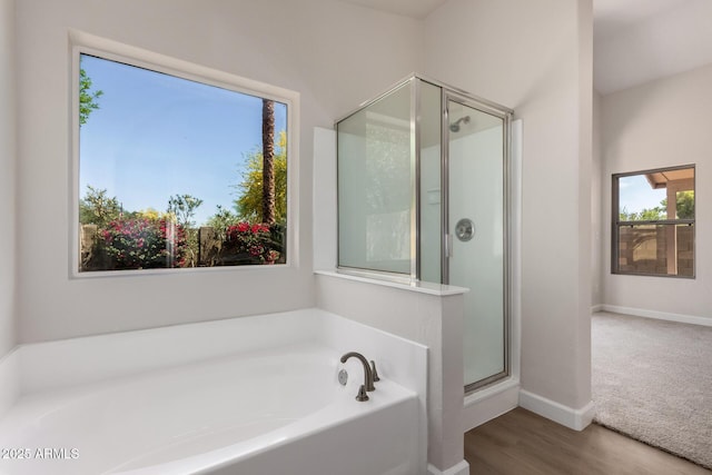 4526 E Bannock St, Phoenix, AZ 85044 - bathroom featuring a bath, a shower stall, baseboards, and wood finished floors