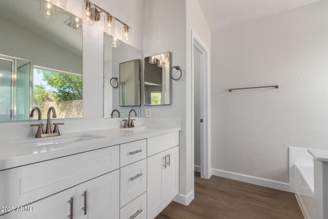 4526 E Bannock St, Phoenix, AZ 85044 - full bathroom featuring wood finished floors, baseboards, lofted ceiling, double vanity, and a tub to relax in