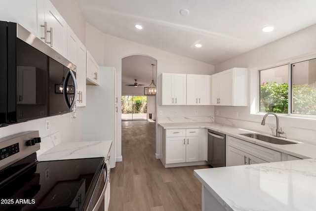 4526 E Bannock St, Phoenix, AZ 85044 - kitchen with appliances with stainless steel finishes, a sink, light stone countertops, vaulted ceiling, and white cabinets