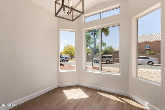 4526 E Bannock St, Phoenix, AZ 85044 - spare room featuring a chandelier, wood finished floors, baseboards, and high vaulted ceiling