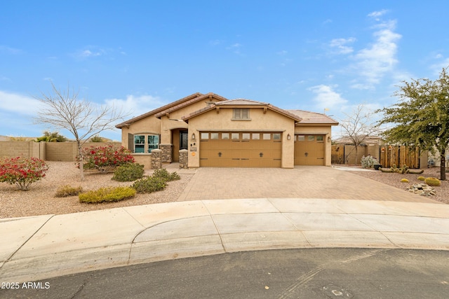 view of front of property with driveway, an attached garage, fence, and stucco siding