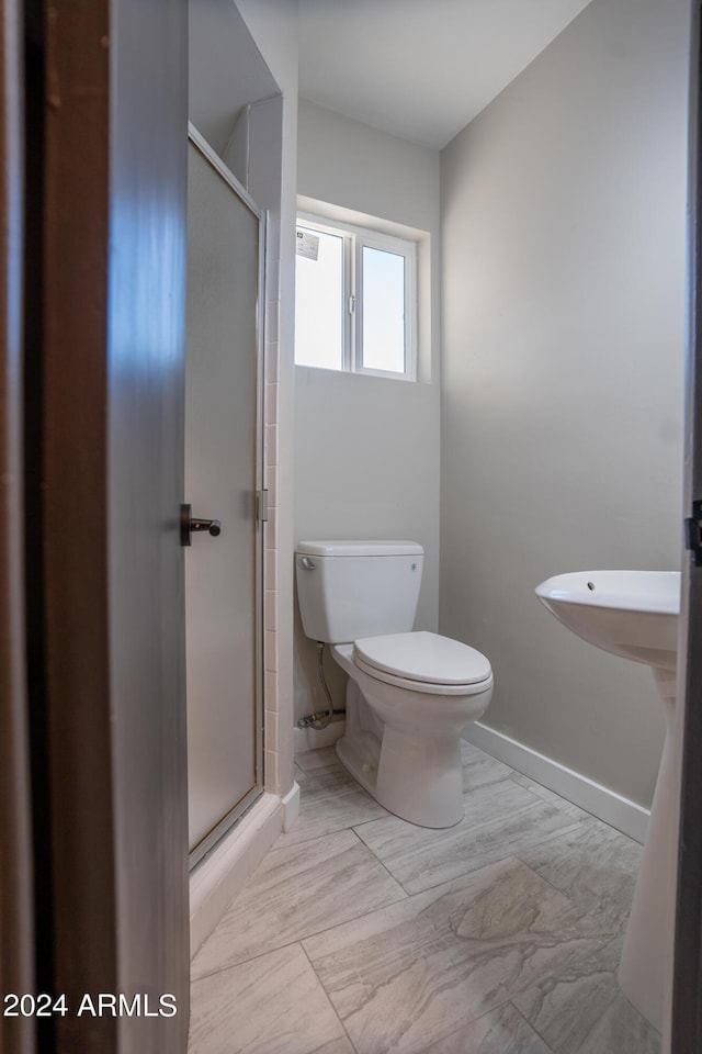 bathroom featuring toilet and an enclosed shower