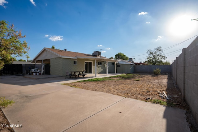 rear view of property featuring central air condition unit and a patio