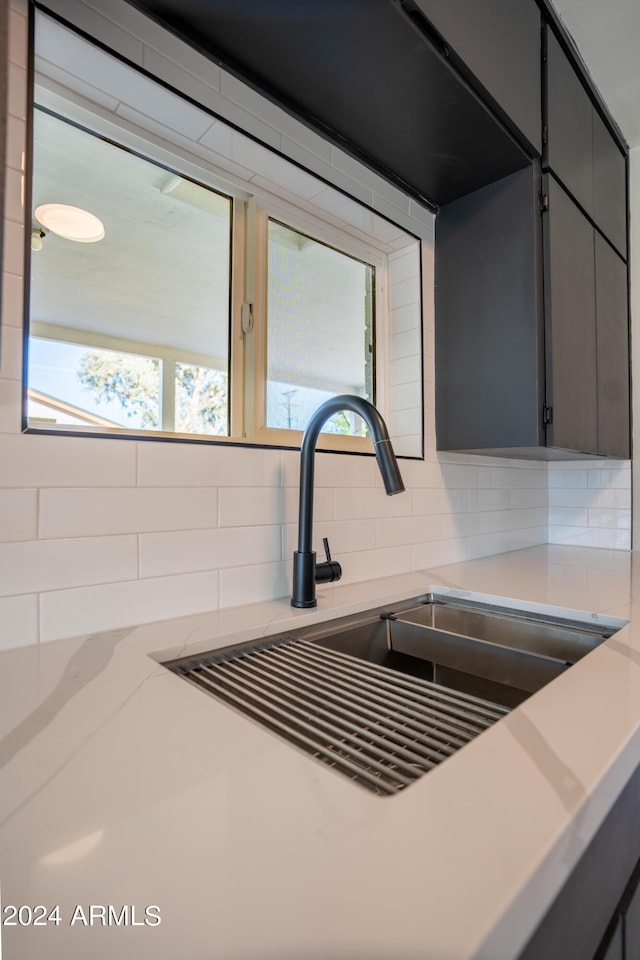 interior details featuring tasteful backsplash, gray cabinets, and sink