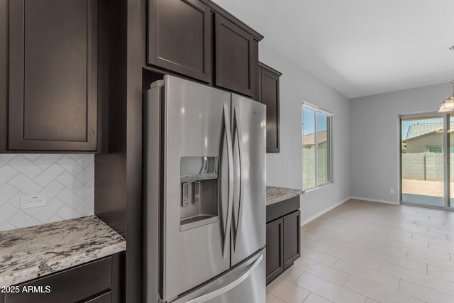 22788 E Orion Way, Queen Creek, AZ 85142 - kitchen featuring stainless steel fridge, tasteful backsplash, dark brown cabinetry, light stone countertops, and decorative light fixtures