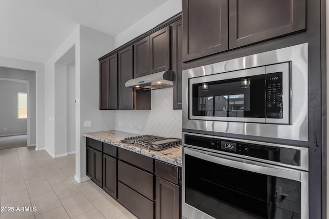 22788 E Orion Way, Queen Creek, AZ 85142 - kitchen featuring appliances with stainless steel finishes, under cabinet range hood, dark brown cabinetry, backsplash, and light stone counters