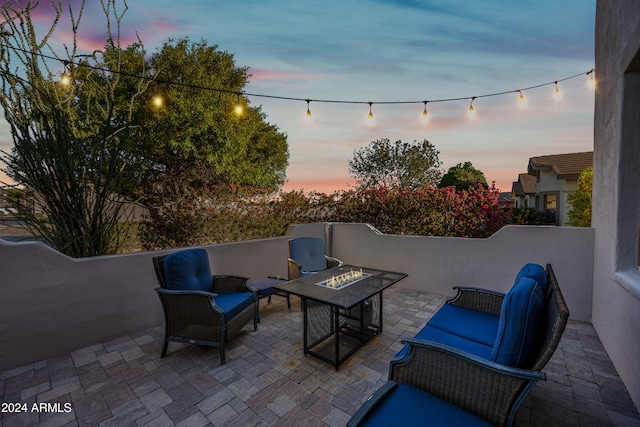 patio terrace at dusk with an outdoor living space with a fire pit