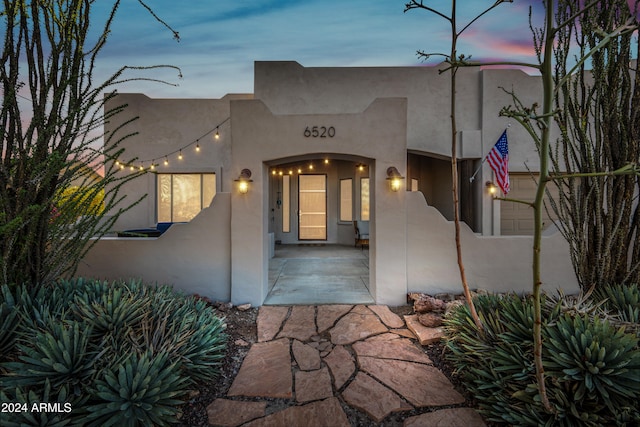 exterior entry at dusk with a patio area