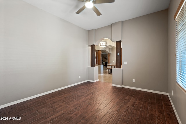 empty room with ceiling fan and dark hardwood / wood-style flooring