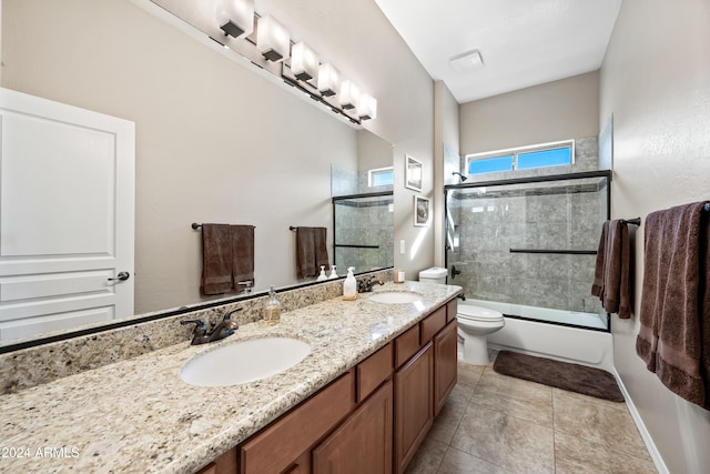 full bathroom with bath / shower combo with glass door, vanity, tile patterned floors, and toilet