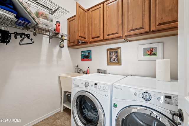 washroom with cabinets, washing machine and dryer, and light tile patterned flooring