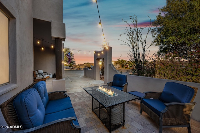 patio terrace at dusk featuring an outdoor living space with a fire pit