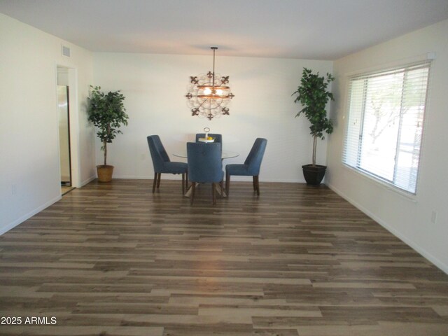 dining room featuring dark wood-type flooring and a chandelier