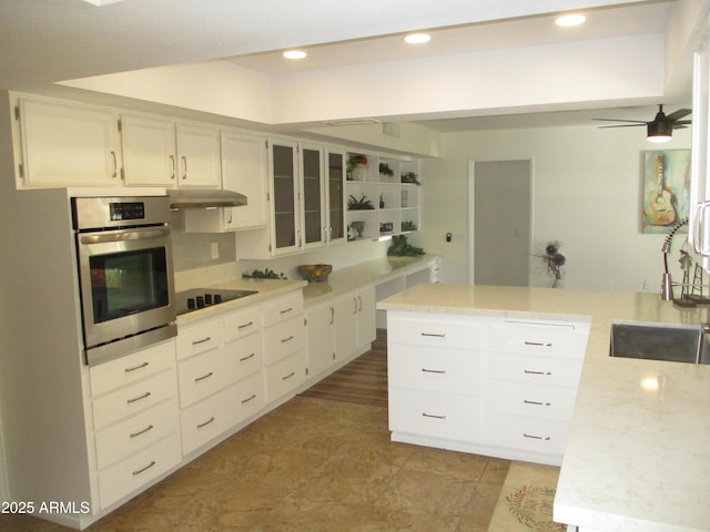 kitchen with sink, white cabinets, a center island, black electric stovetop, and stainless steel oven