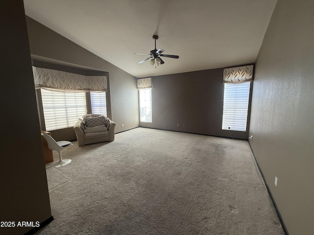 interior space featuring carpet floors, a healthy amount of sunlight, vaulted ceiling, and a ceiling fan