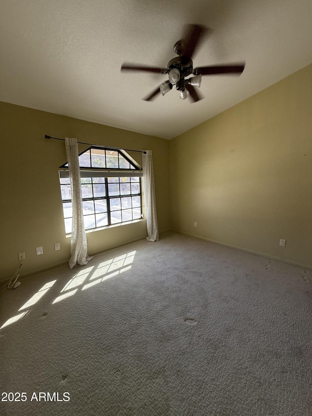 unfurnished room with ceiling fan, a textured ceiling, and light colored carpet