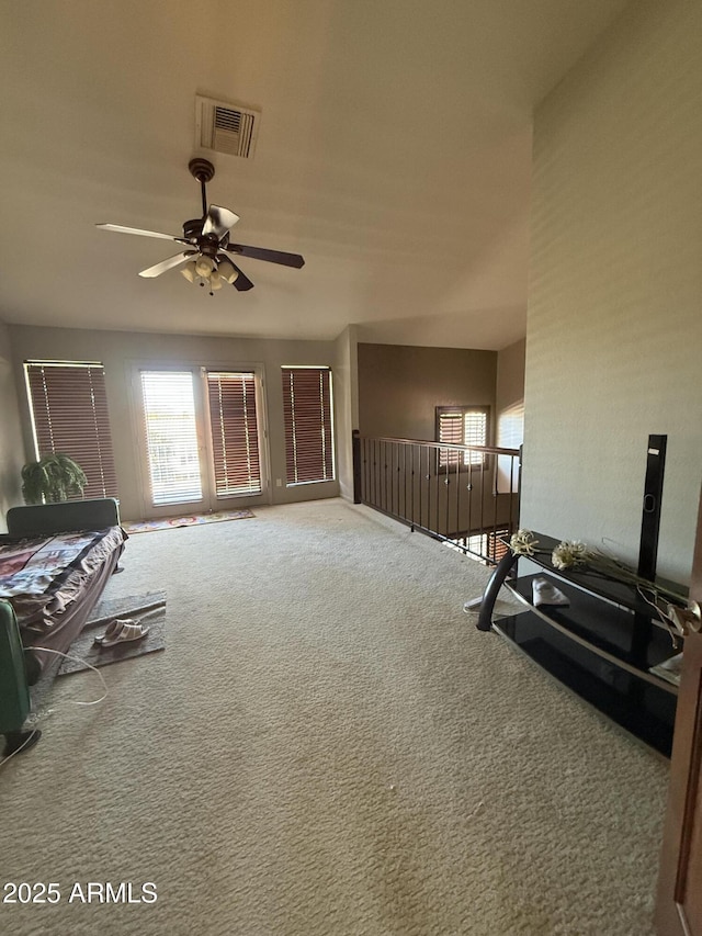 carpeted living room featuring visible vents and ceiling fan