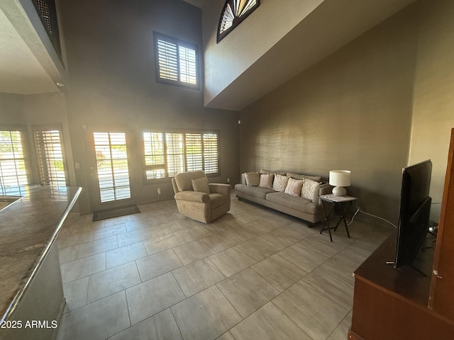 unfurnished living room with a high ceiling and light tile patterned floors