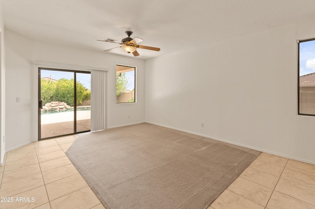 39609 N White Tail Ln, Anthem, AZ 85086 - empty room featuring visible vents, baseboards, ceiling fan, and light tile patterned flooring