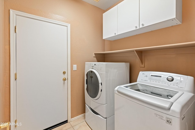 39609 N White Tail Ln, Anthem, AZ 85086 - laundry area featuring separate washer and dryer, baseboards, light tile patterned floors, and cabinet space