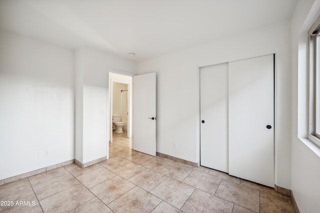 6309 W Hughes Dr, Phoenix, AZ 85043 - unfurnished bedroom featuring a closet, light tile patterned floors, and baseboards